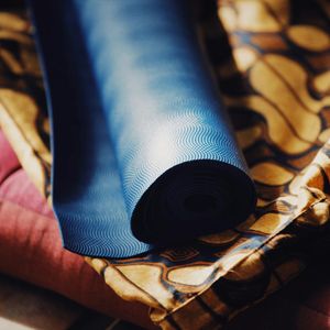 Close-up of a rolled up teal yoga mat.